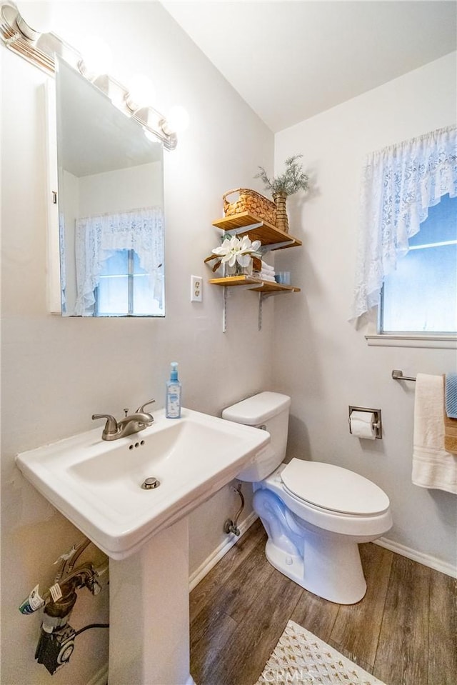 bathroom featuring toilet, plenty of natural light, and wood finished floors