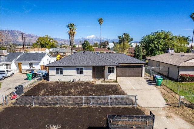 ranch-style house with driveway, a fenced front yard, and a mountain view