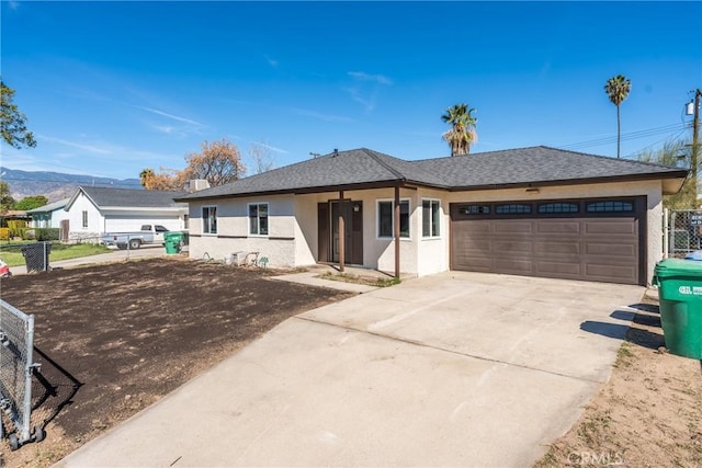 ranch-style home with an attached garage, driveway, fence, and stucco siding