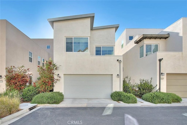 114 Source, Irvine, CA 92618 - view of property with an attached garage, stucco siding, and driveway