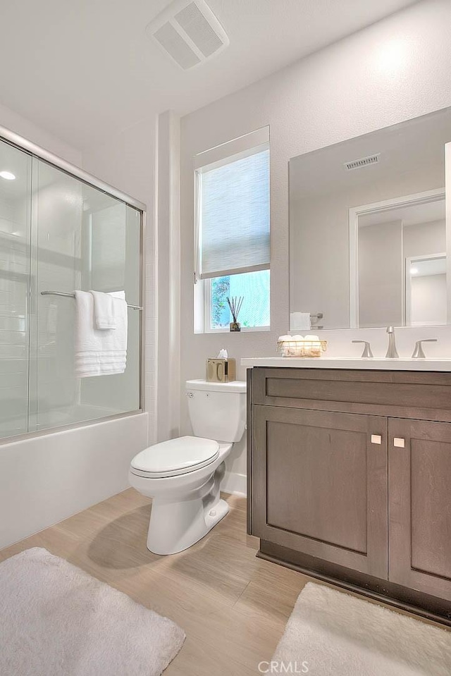 114 Source, Irvine, CA 92618 - full bath with toilet, vanity, enclosed tub / shower combo, and wood finished floors
