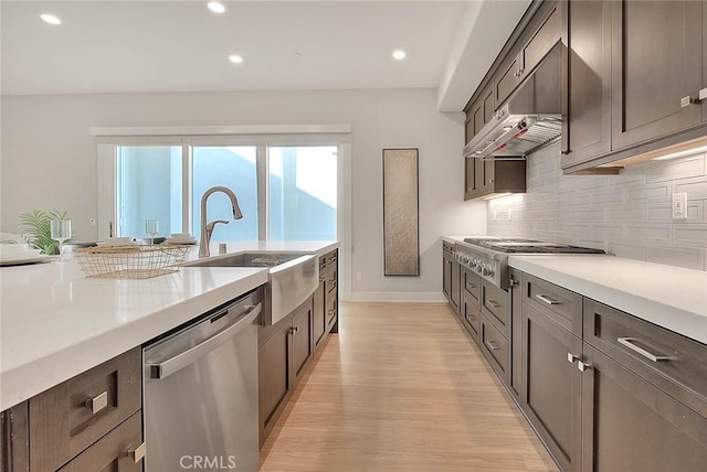 114 Source, Irvine, CA 92618 - kitchen with stainless steel appliances, decorative backsplash, light countertops, light wood-style floors, and recessed lighting