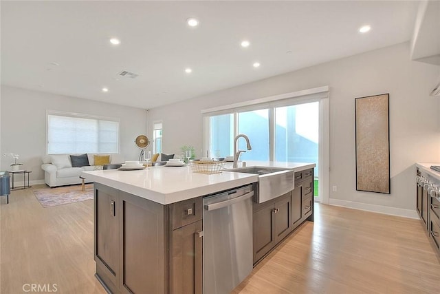 114 Source, Irvine, CA 92618 - kitchen with stainless steel dishwasher, an island with sink, light wood-style floors, light countertops, and recessed lighting