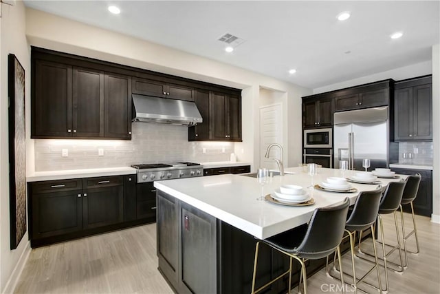114 Source, Irvine, CA 92618 - kitchen with a sink, under cabinet range hood, built in appliances, backsplash, and light countertops