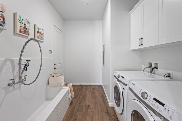 laundry room featuring dark wood-type flooring, washing machine and dryer, cabinet space, and baseboards