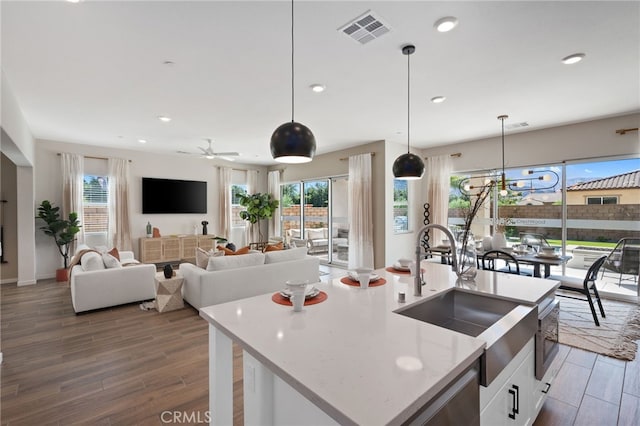 kitchen featuring recessed lighting, dark wood-style flooring, a sink, white cabinetry, and visible vents