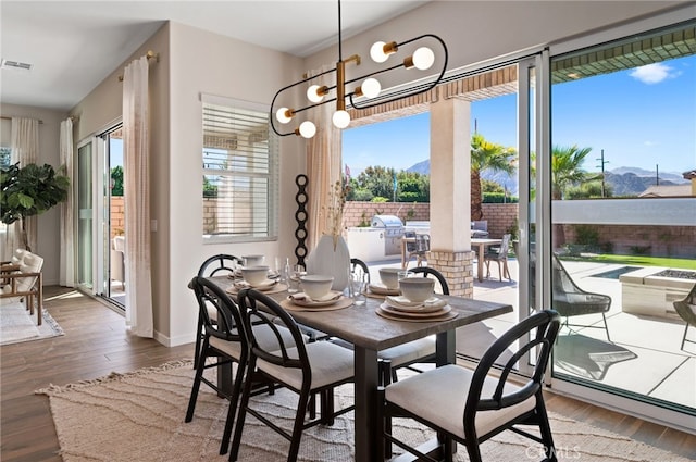 dining area featuring a mountain view, visible vents, a chandelier, and wood finished floors