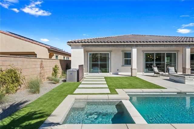 back of house featuring an in ground hot tub, fence, a fenced in pool, stucco siding, and a patio area