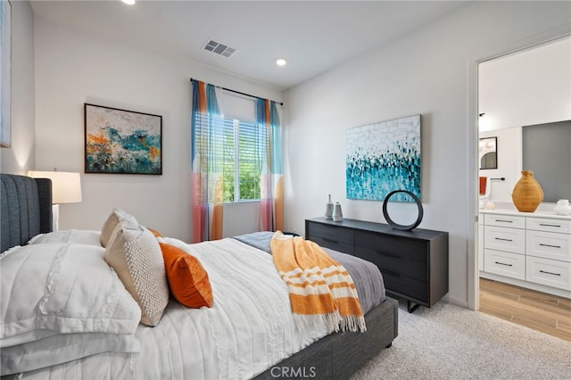 bedroom featuring connected bathroom, light colored carpet, recessed lighting, visible vents, and baseboards