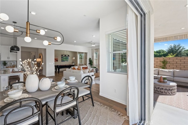 dining space with a wealth of natural light, ceiling fan, baseboards, and wood finished floors