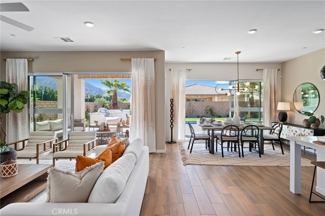 living area featuring a chandelier, recessed lighting, visible vents, and wood finished floors