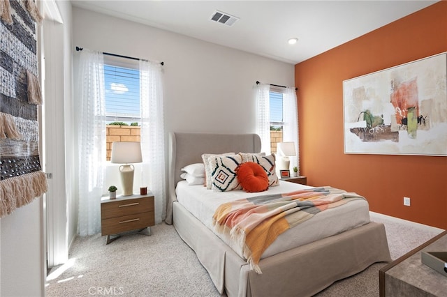 bedroom featuring carpet floors, multiple windows, and visible vents