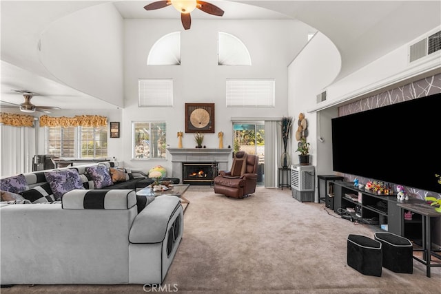 41149 Summitview Ln, Palmdale, CA 93551 - living area featuring ceiling fan, carpet, healthy amount of natural light, a lit fireplace, and a towering ceiling