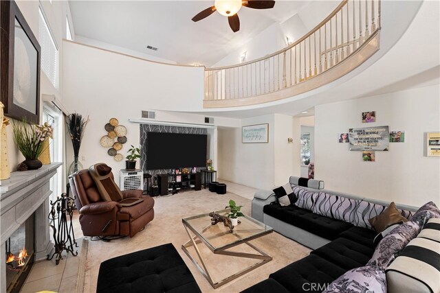 41149 Summitview Ln, Palmdale, CA 93551 - living area featuring a tiled fireplace, a towering ceiling, a ceiling fan, tile patterned floors, and carpet floors