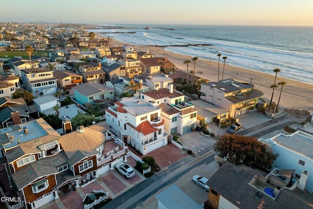 aerial view at dusk with a residential view, a beach view, and a water view