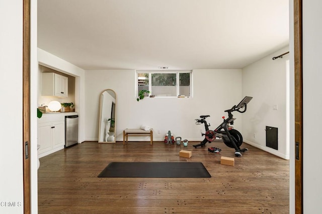 workout room featuring baseboards and dark wood-style flooring