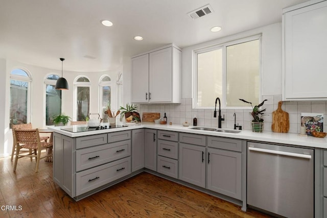 kitchen featuring visible vents, gray cabinetry, dishwasher, black electric cooktop, and a sink