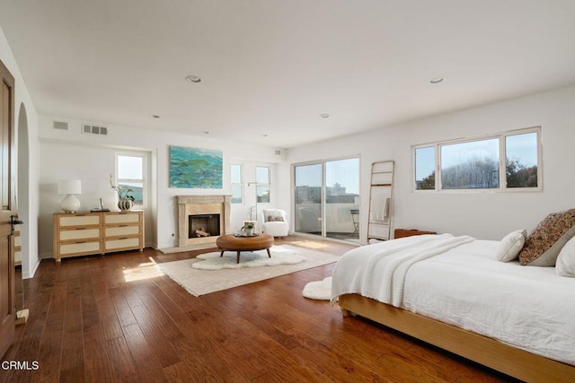 bedroom featuring visible vents, recessed lighting, a high end fireplace, hardwood / wood-style flooring, and access to outside