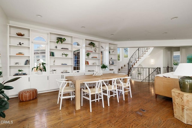 dining room featuring recessed lighting, hardwood / wood-style floors, and stairs