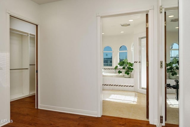 corridor featuring baseboards and wood finished floors