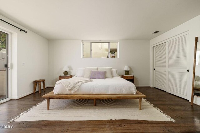bedroom featuring a closet, baseboards, visible vents, and dark wood-style flooring