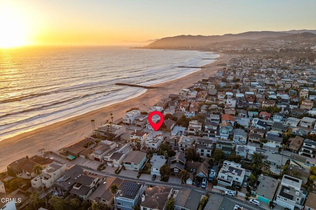 drone / aerial view with a view of the beach, a residential view, and a water and mountain view