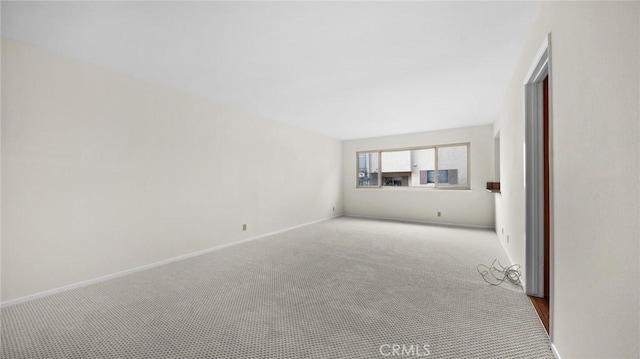 unfurnished living room featuring carpet flooring and baseboards