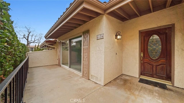 entrance to property with a balcony and stucco siding