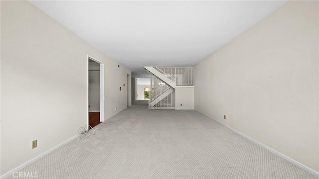 unfurnished living room featuring carpet and baseboards