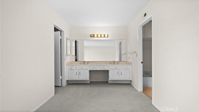 bathroom with visible vents, a sink, baseboards, and double vanity