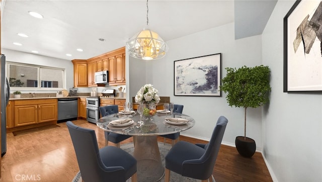 dining space with light wood-style flooring, baseboards, and recessed lighting