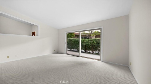 carpeted spare room featuring baseboards