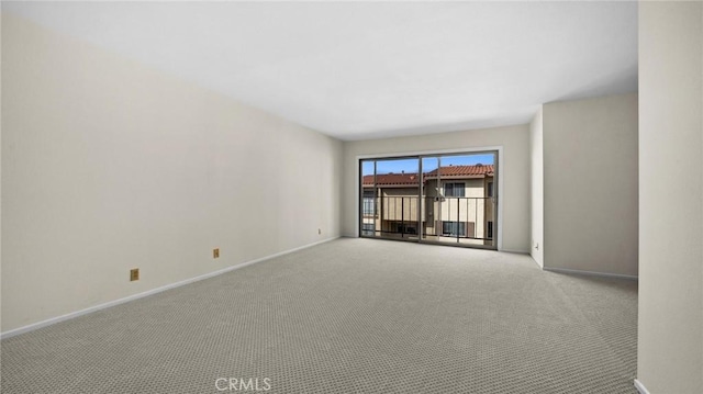 empty room featuring carpet flooring and baseboards