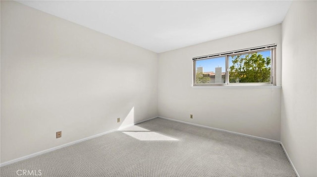 carpeted spare room with baseboards