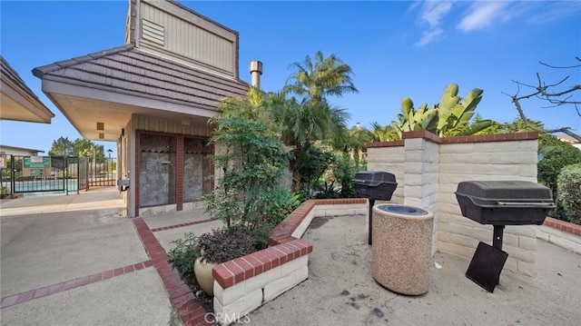 view of patio with fence and a grill