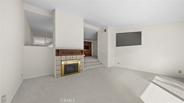 living room with carpet floors, visible vents, a fireplace, and baseboards