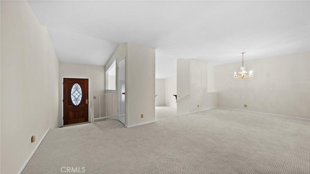 foyer with light carpet, baseboards, and a notable chandelier