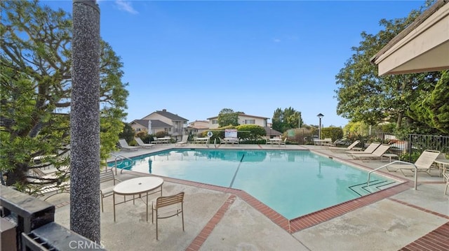 community pool featuring a patio area and fence