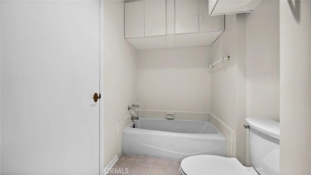 bathroom featuring a bath, tile patterned flooring, and toilet