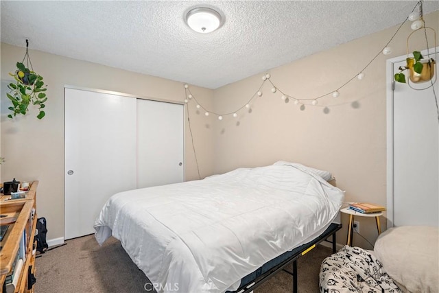 carpeted bedroom featuring a textured ceiling and a closet