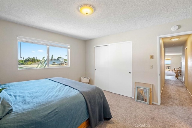 carpeted bedroom with a closet and a textured ceiling