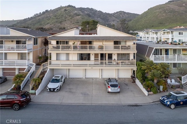 view of building exterior featuring driveway, an attached garage, and a mountain view