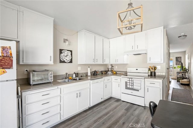 kitchen featuring white cabinets, a sink, wood finished floors, white appliances, and under cabinet range hood