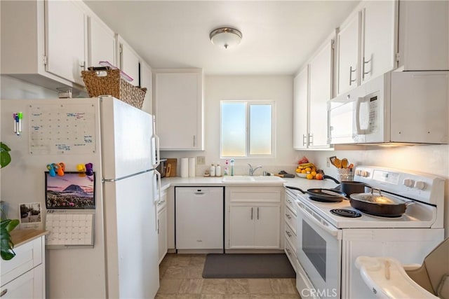 kitchen featuring white appliances, light countertops, a sink, and white cabinets