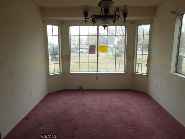 unfurnished dining area with carpet flooring and an inviting chandelier