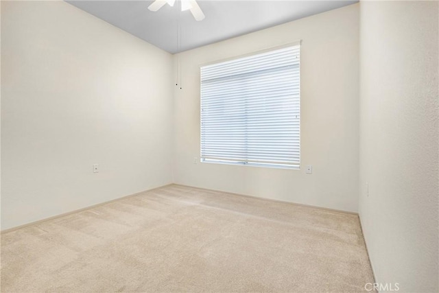 carpeted empty room with a ceiling fan