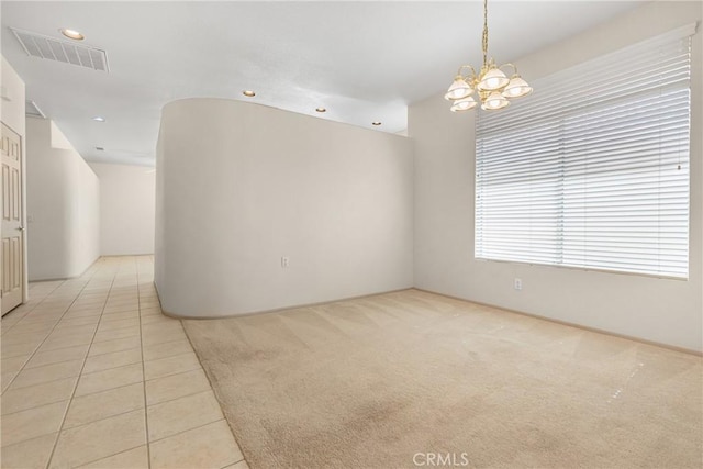 spare room featuring light carpet, light tile patterned floors, visible vents, an inviting chandelier, and recessed lighting