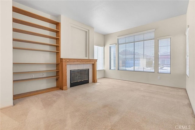 unfurnished living room featuring carpet, a fireplace, and built in features