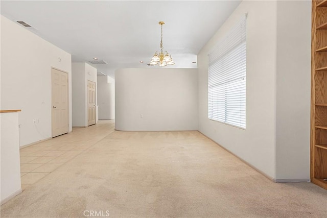 empty room with visible vents, an inviting chandelier, light tile patterned flooring, and light colored carpet