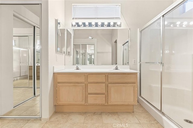 full bath with tile patterned flooring, a sink, a shower stall, and double vanity